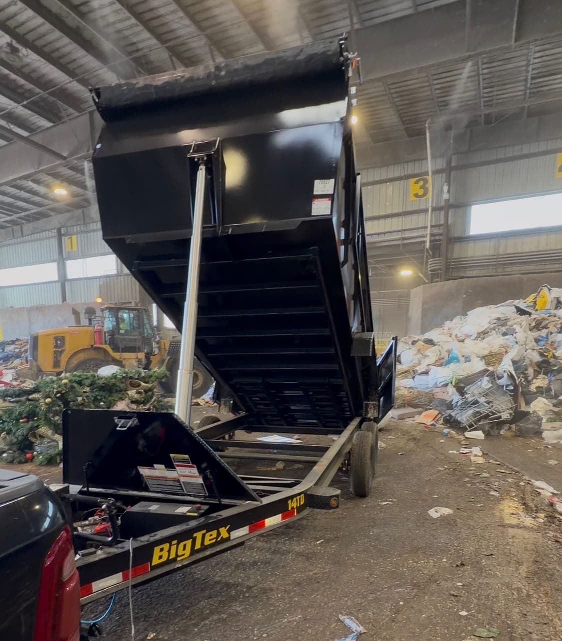 Dump Happy trailer tipping a load of debris at a certified recycling and disposal facility
