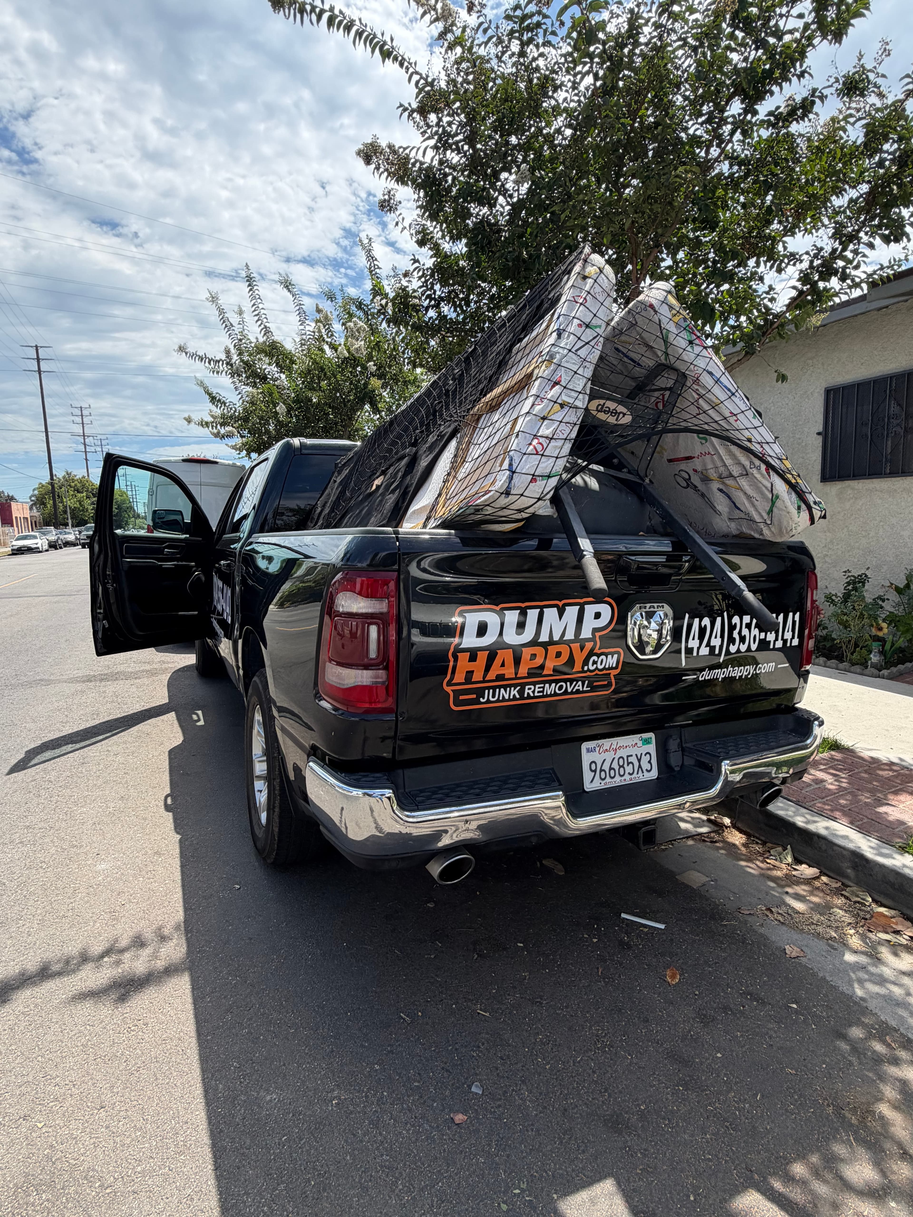 Dump Happy branded truck loaded with mattresses for a mattress removal job in Los Angeles